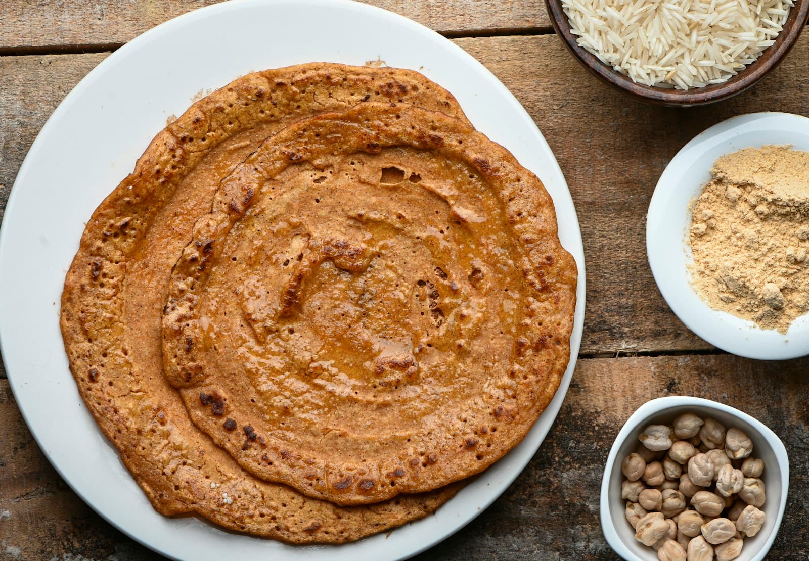 A close-up of whole-grain Indian roti on a white ceramic plate — wholesome millet/ragi-style flatbread.