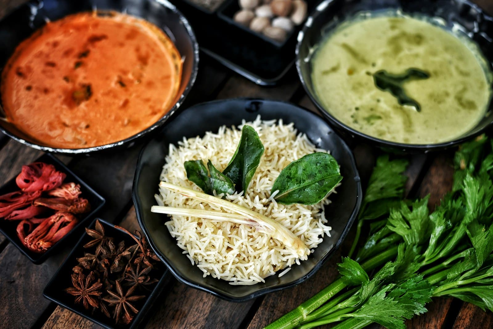 Three bowls of warm Indian comfort food — rice, dal, sabzi — laid out together.