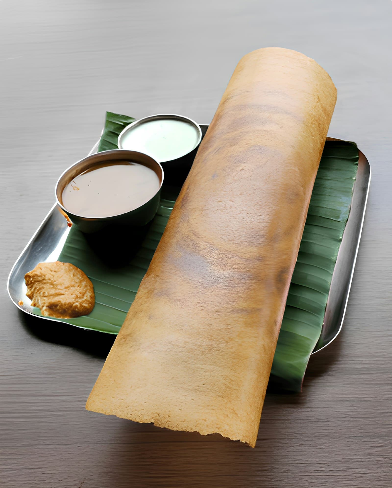 A crisp dosa fanned out on a plate with fresh chutneys alongside — a single nourishing Indian breakfast.